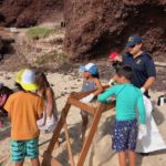 Young and old help to clean the beach